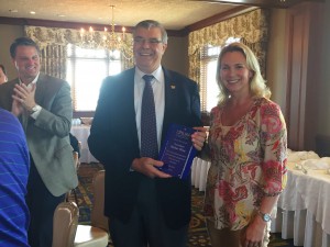 Jacqueline Kirby, AstraZeneca, presents an award to President Walter Wise for his service as chairman